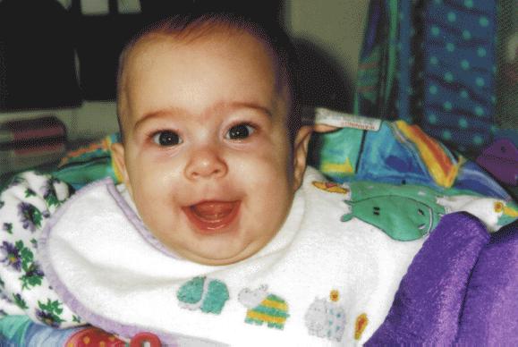 Cute baby girl, a bit older, laughing.