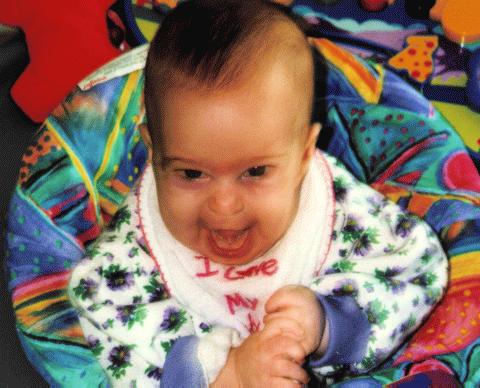 Cute baby girl laughing outloud in exersaucer